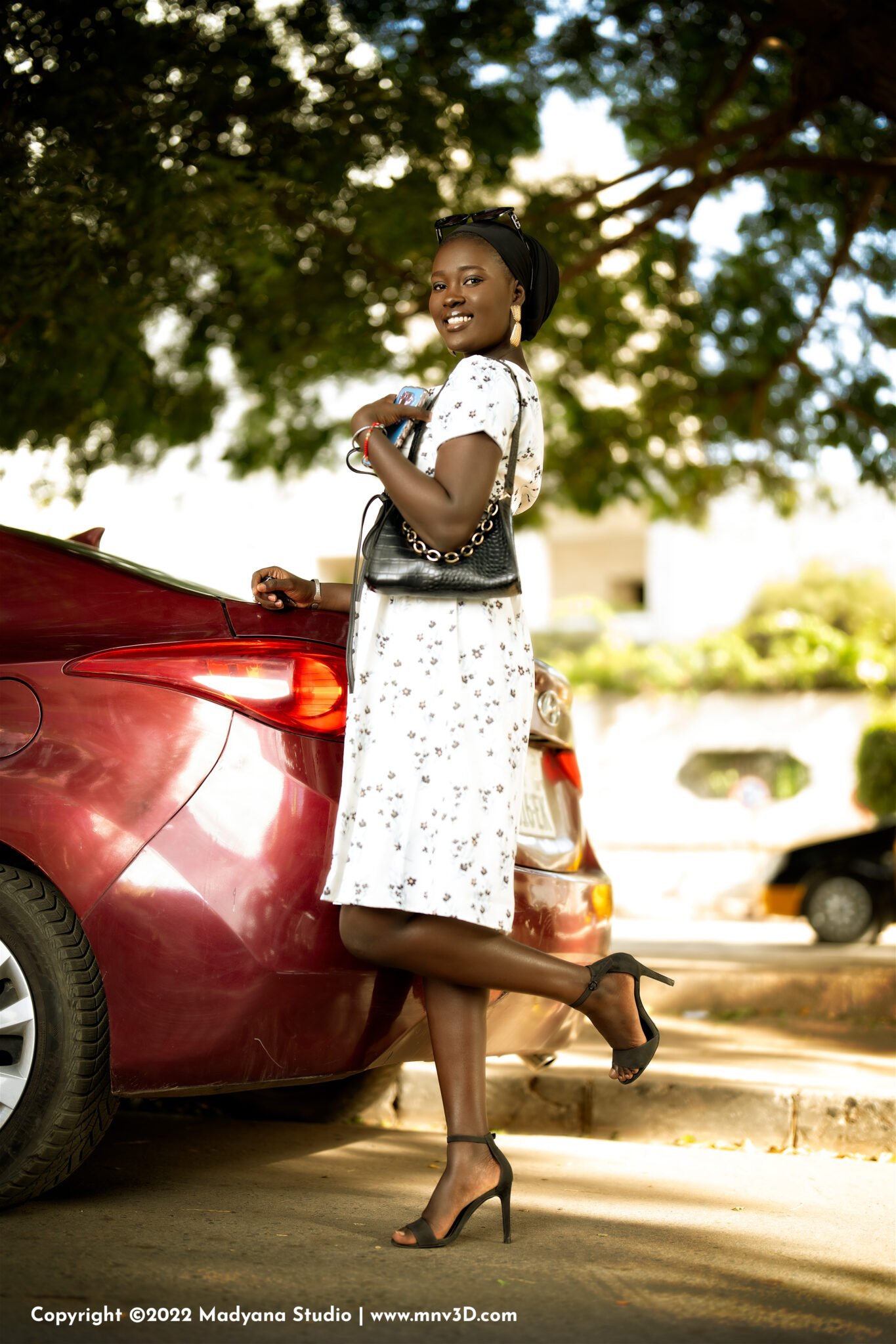 Professional Fashion photography in Dakar City road street, Senegal. Luxury fashion red car. Beautiful female African model, Kira